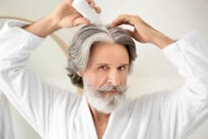 topical serum for hair loss applied by an older man